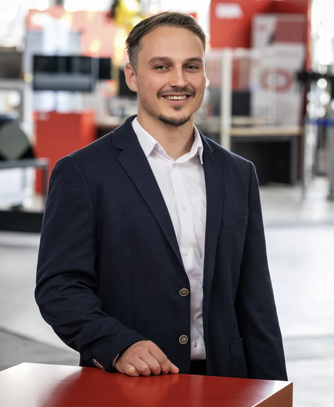 Emil Harlan im Anzug in einer technischen Ausstellung